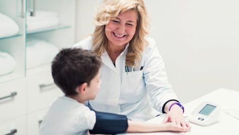 Una enfermera escolar con un niño.