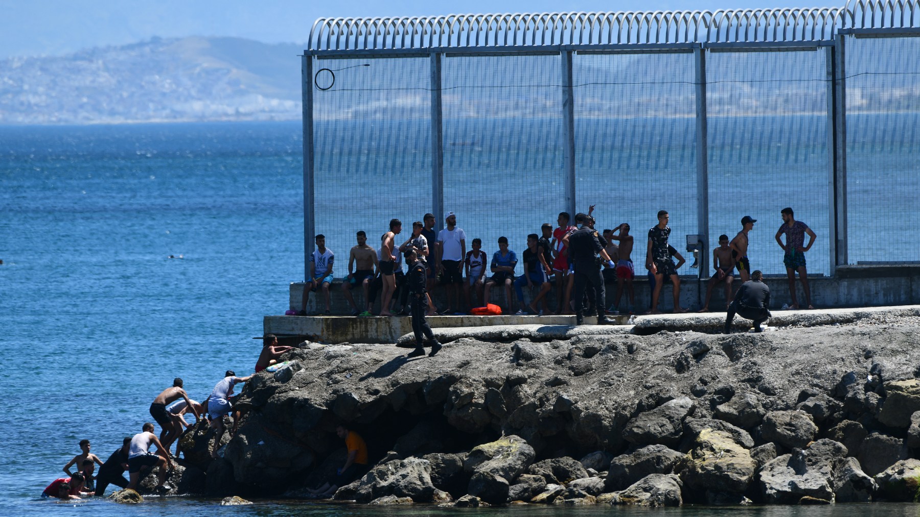 Un grupo de inmigrantes ilegales marroquíes en las inmediaciones de la valla de Ceuta (EUROPA PRESS).