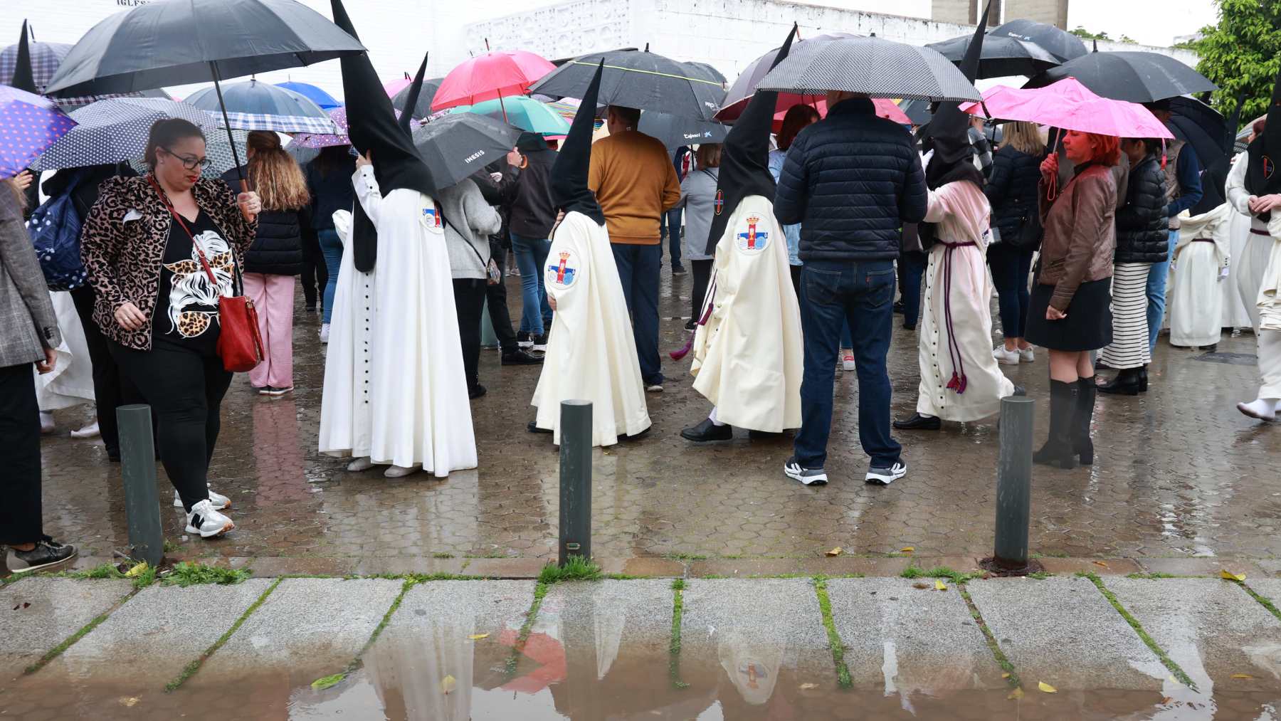 Nazarenos de la Hermandad del Cautivo de San Pablo salen de la Iglesia tras suspenderse por la lluvia su estación de penitencia