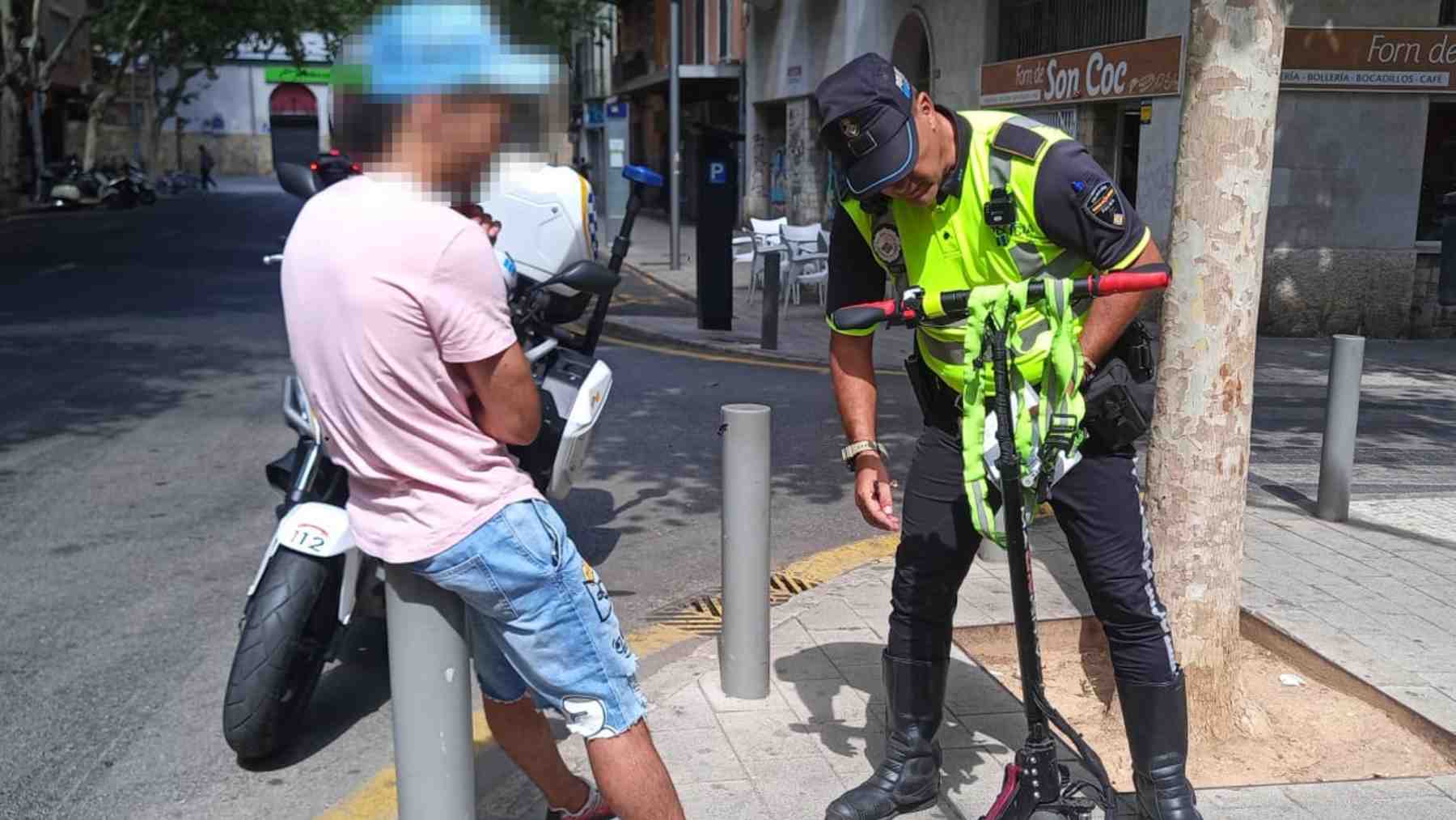 Un agente de la Policía Local de Palma inspecciona un patinete.