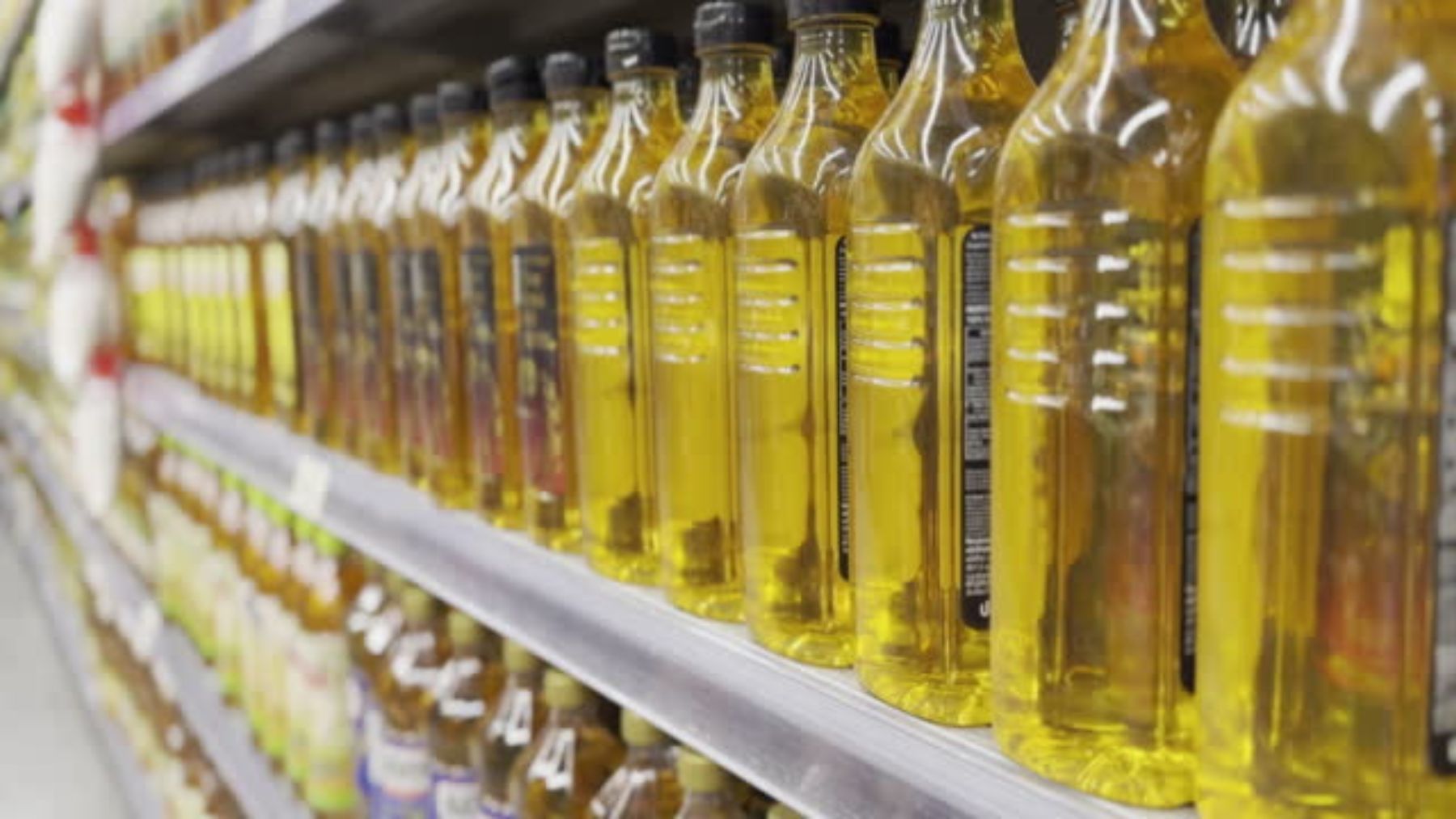 Un estante de supermercado con aceite de oliva.