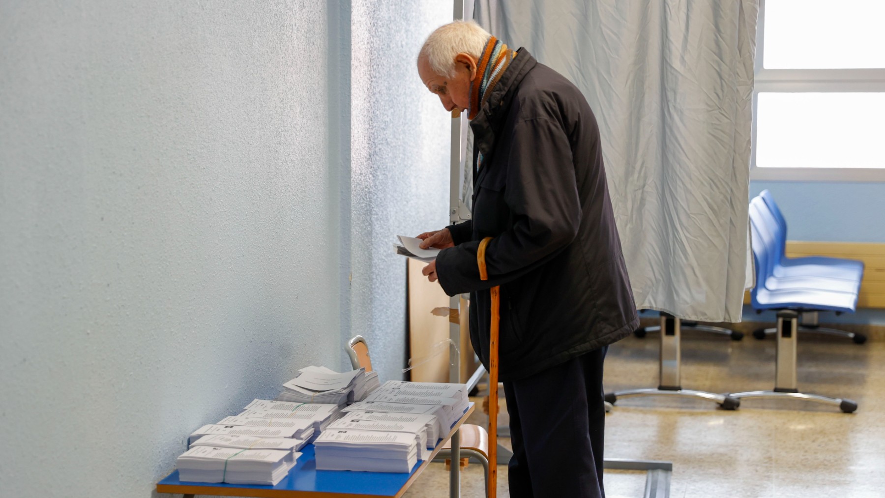 Un votante coge un papeleta.