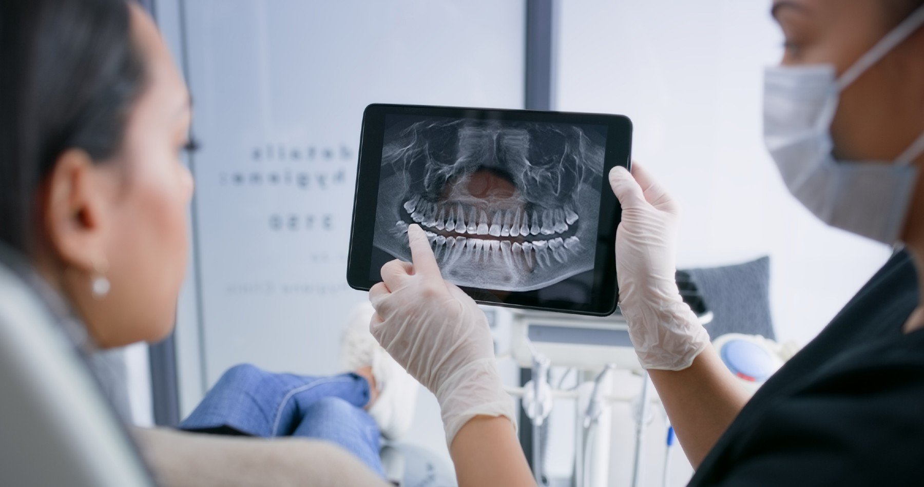 Una doctora explica a la paciente una radiografía dental.