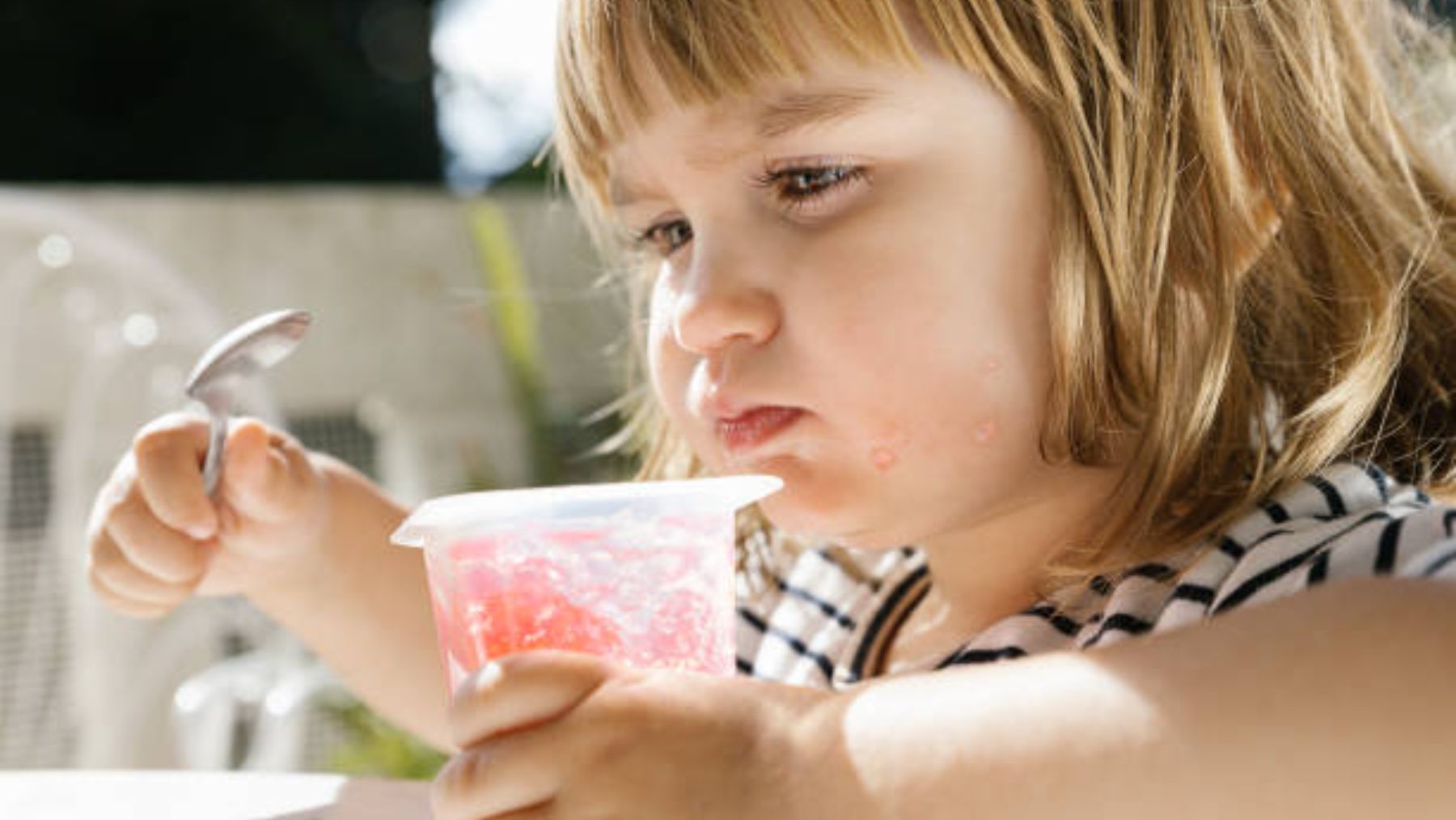 Niña comiendo postre con una cuchara.