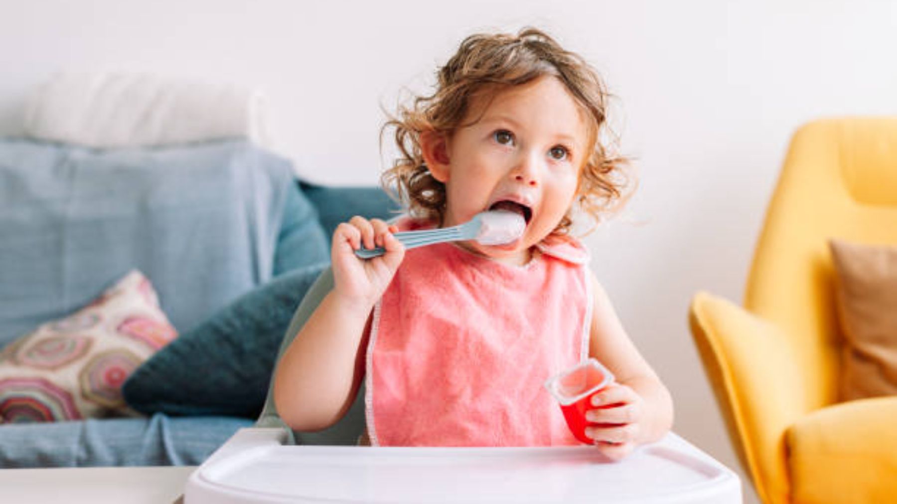 Niño pequeño comiendo solo.