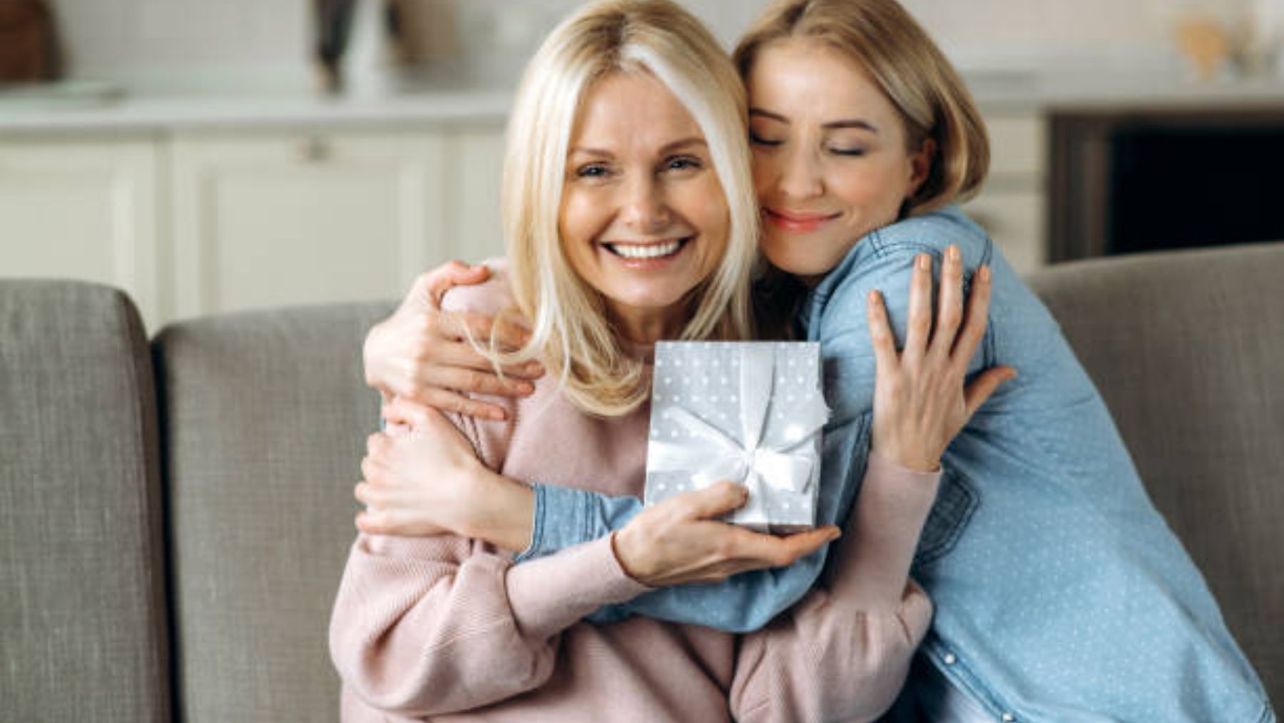 Madre e hija con un regalo abrazadas.