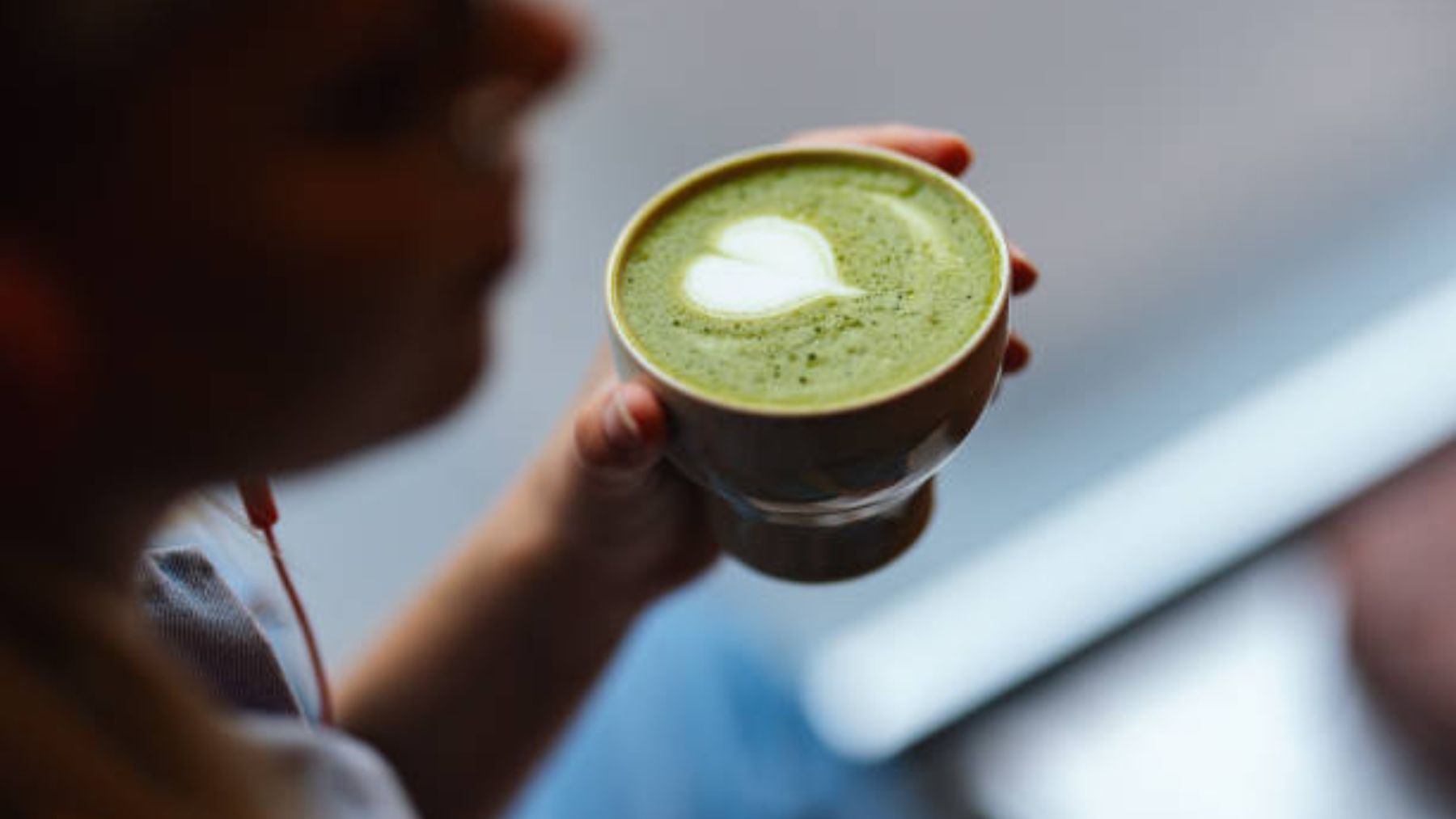 Mujer sosteniendo taza de té matcha.