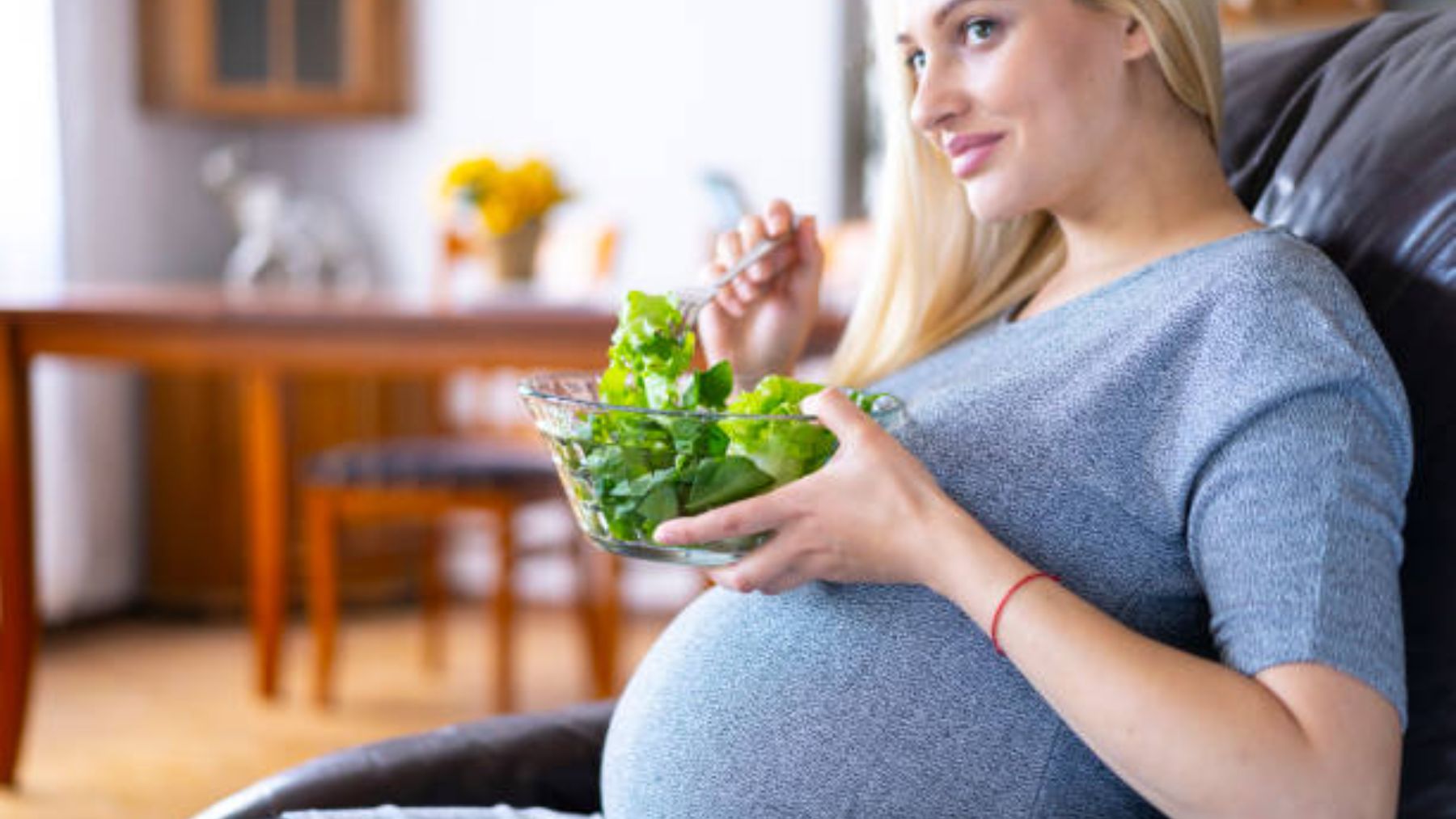 Mujer embarazada comiendo ensalada.