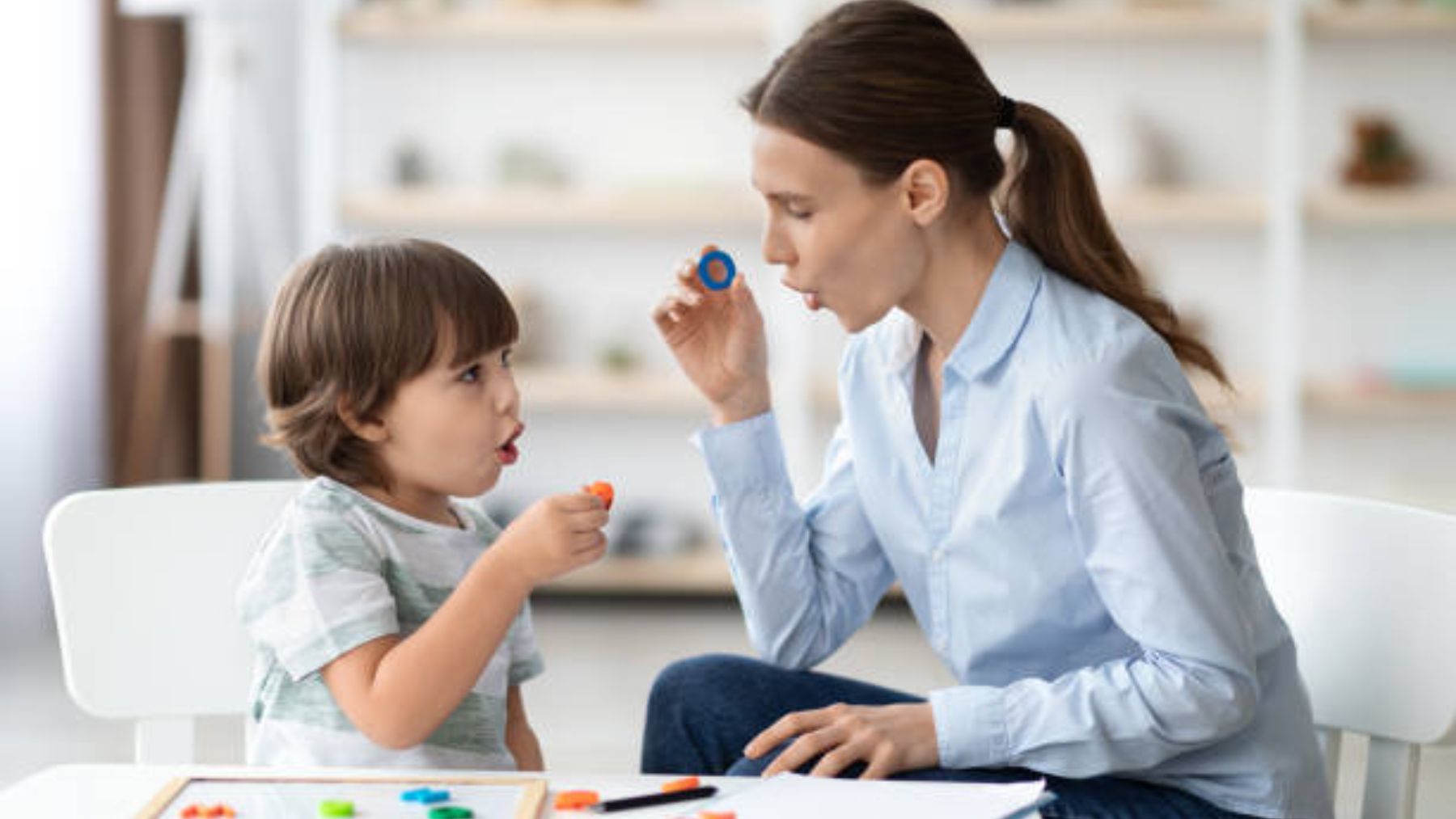 Niño con una profesora hablando.