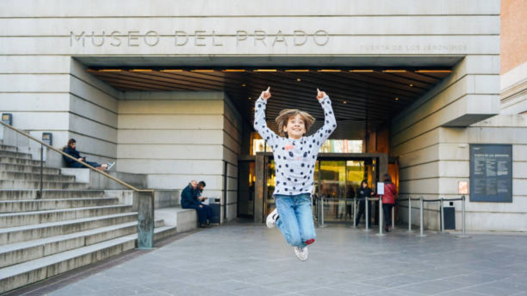 Niño saltando a la entrada del Museo del Prado.