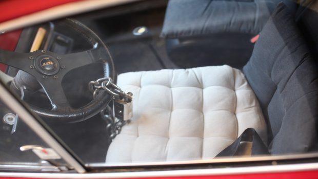 Interior de coche con un candado en el volante.