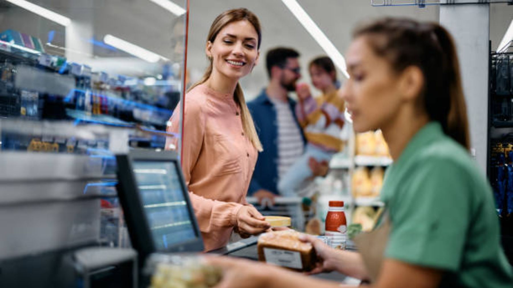 Mujer sonriendo en la caja del supermercado.