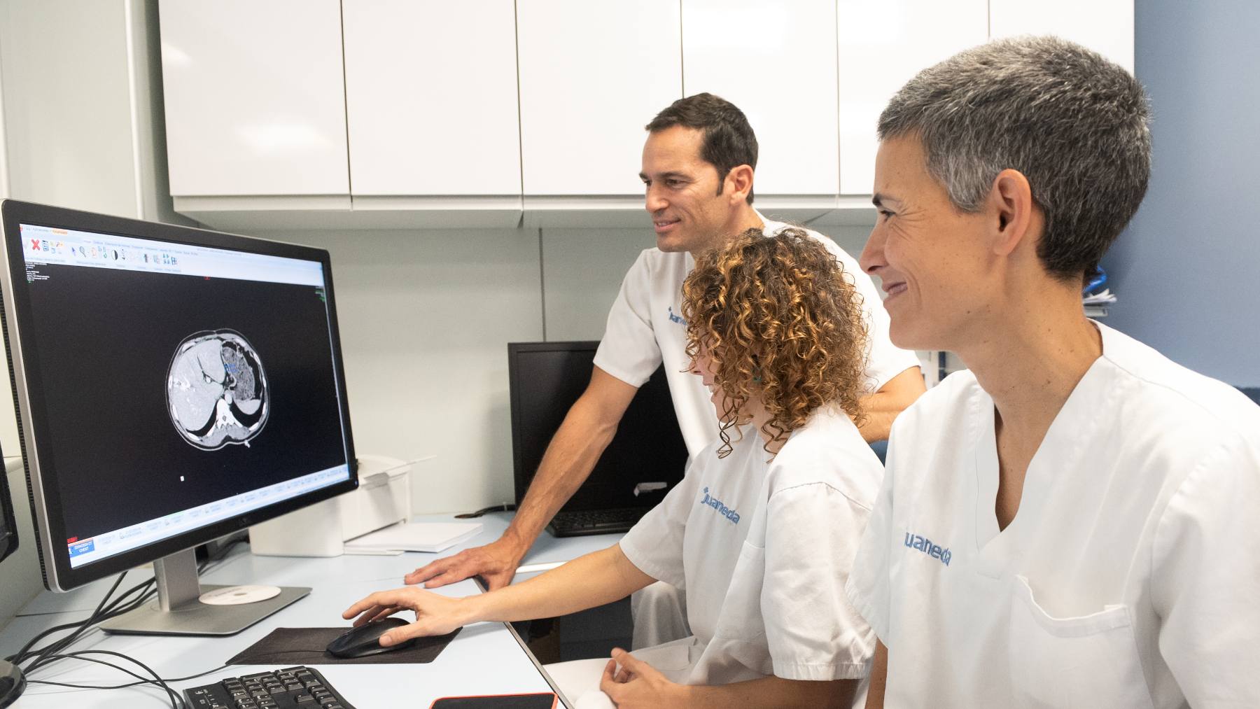 El Dr. Casares y las Dras. Gelabert y Alguersuari ante uno de los monitores de la sala de control de la unidad de radiología intervencionista.