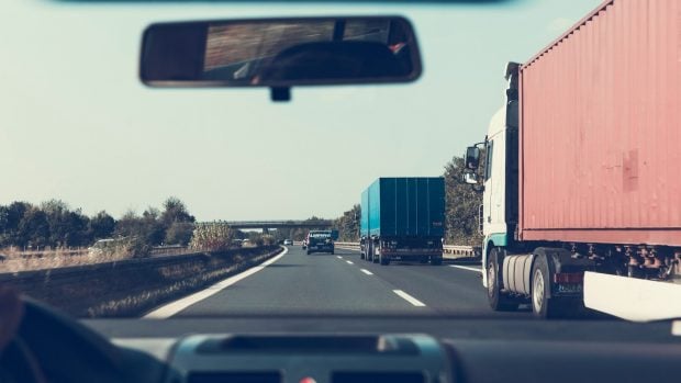 Interior de un coche desde donde se ve el adelantamiento a camiones.