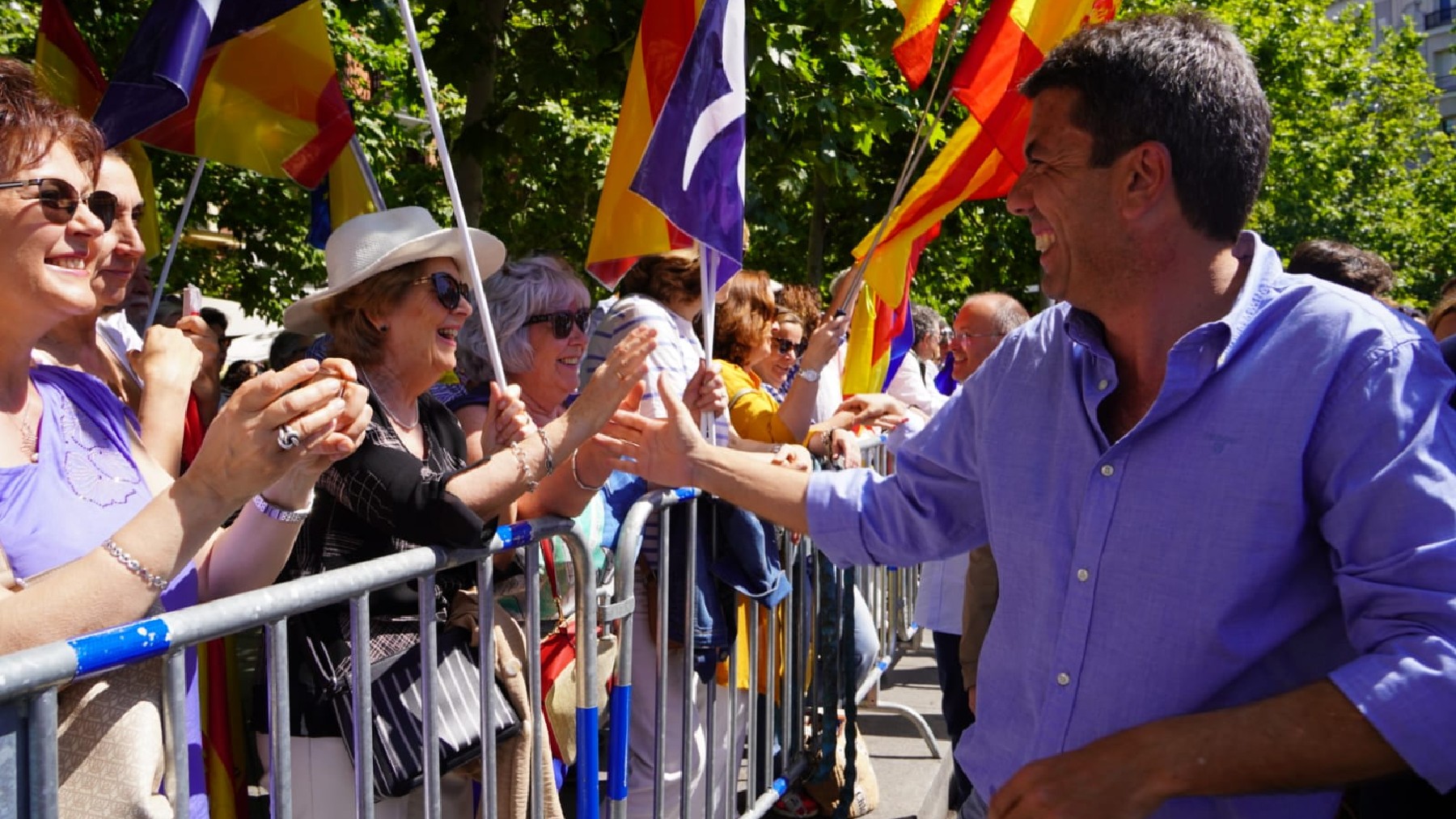 Carlos Mazón saluda a una asistente al acto del PP en Madrid, este domingo.