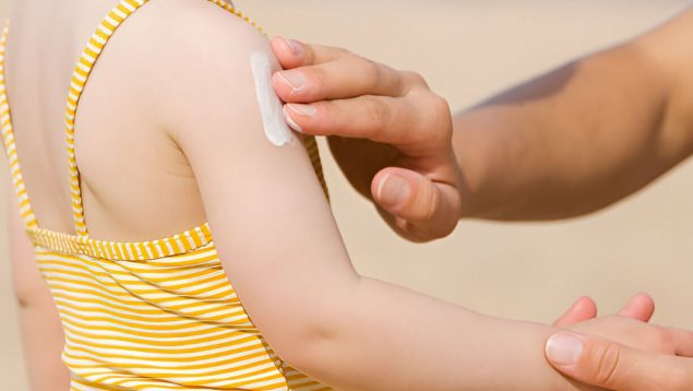 Crema solar en el brazo de una niña.