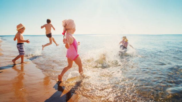 Niños pequeños corriendo en el mar.