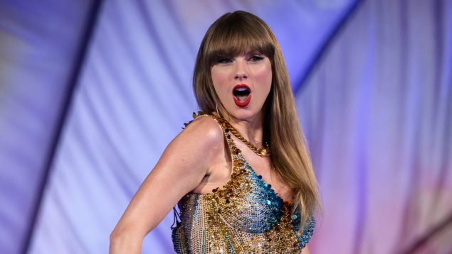 Taylor Swift en un concierto con un body de variois colores