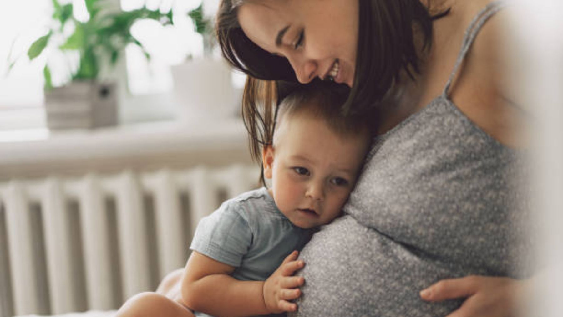 Niño pequeño junto a su madre embarazada.