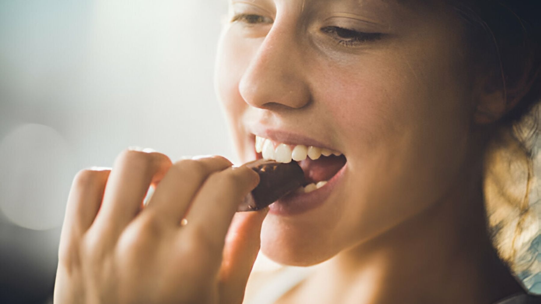 Chica comiendo barrita de chocolate.