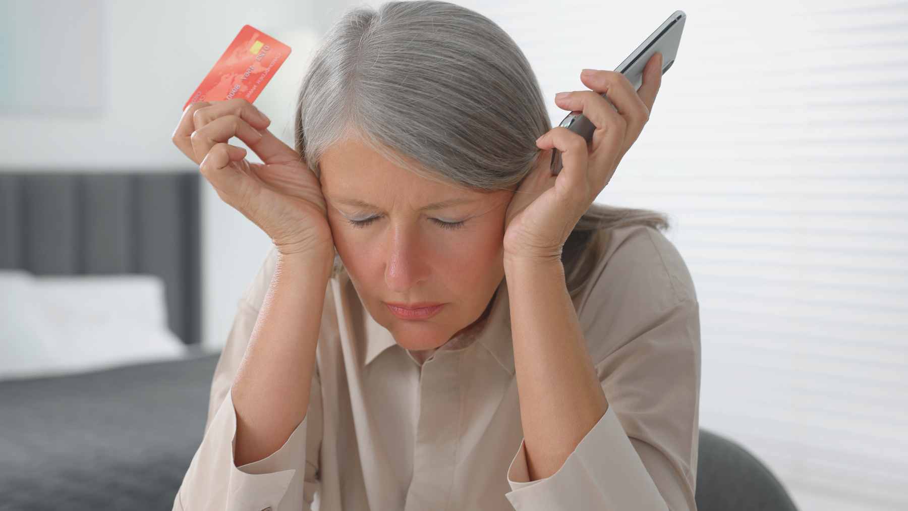 Mujer con un teléfono y una tarjeta de crédito.