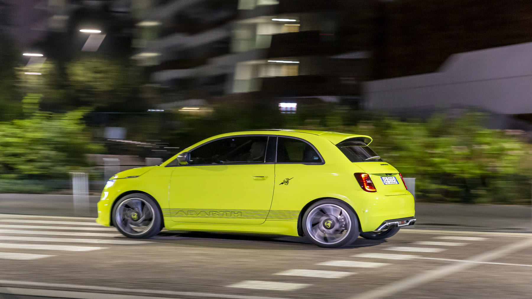 El Abarth 500e en amarillo por la ciudad de noche