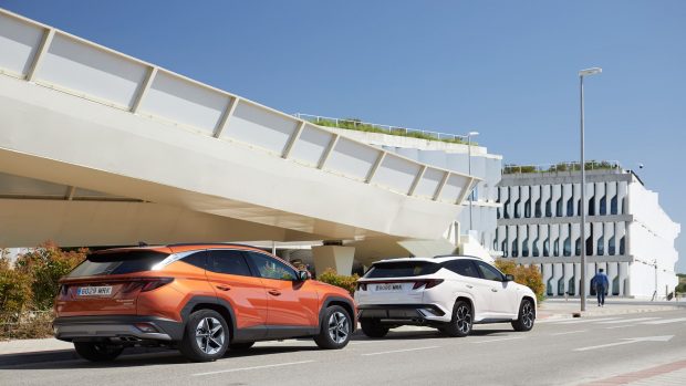 Dos Hyundai Tucson de colores blanco y naranja en vista trasera