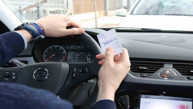 Conductor mostrando su carnet de conducir.