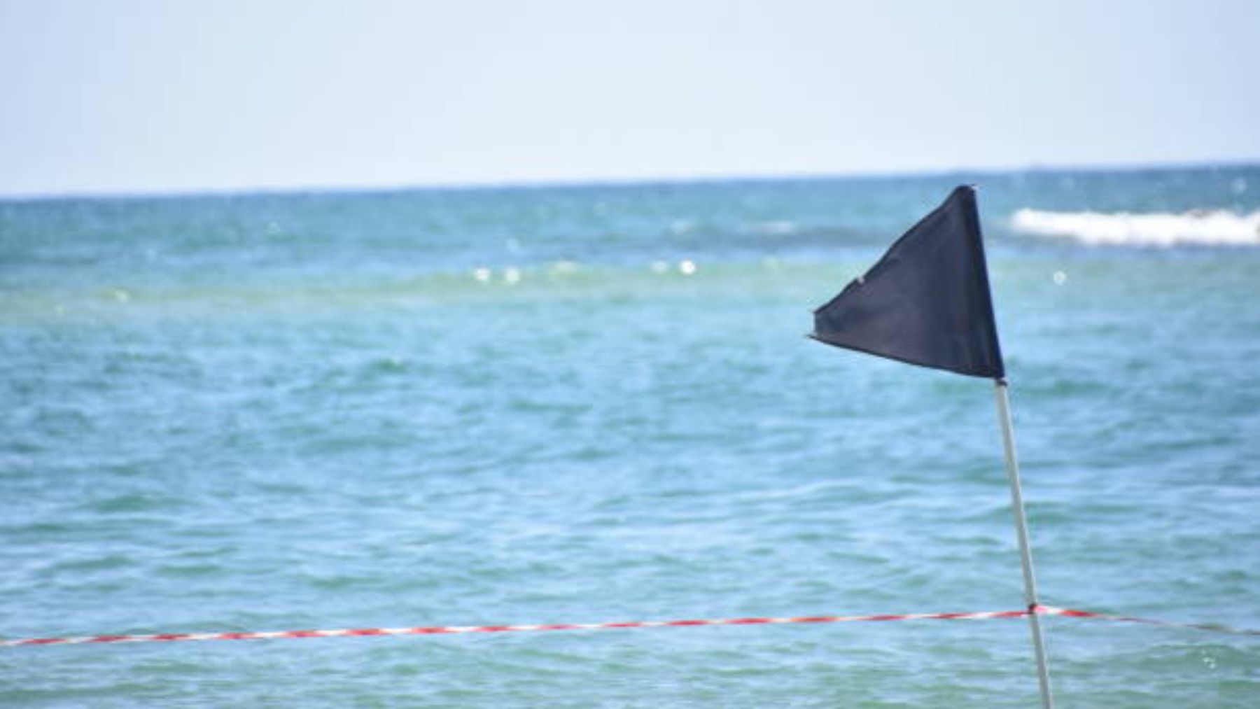 Bandera negra en una playa.