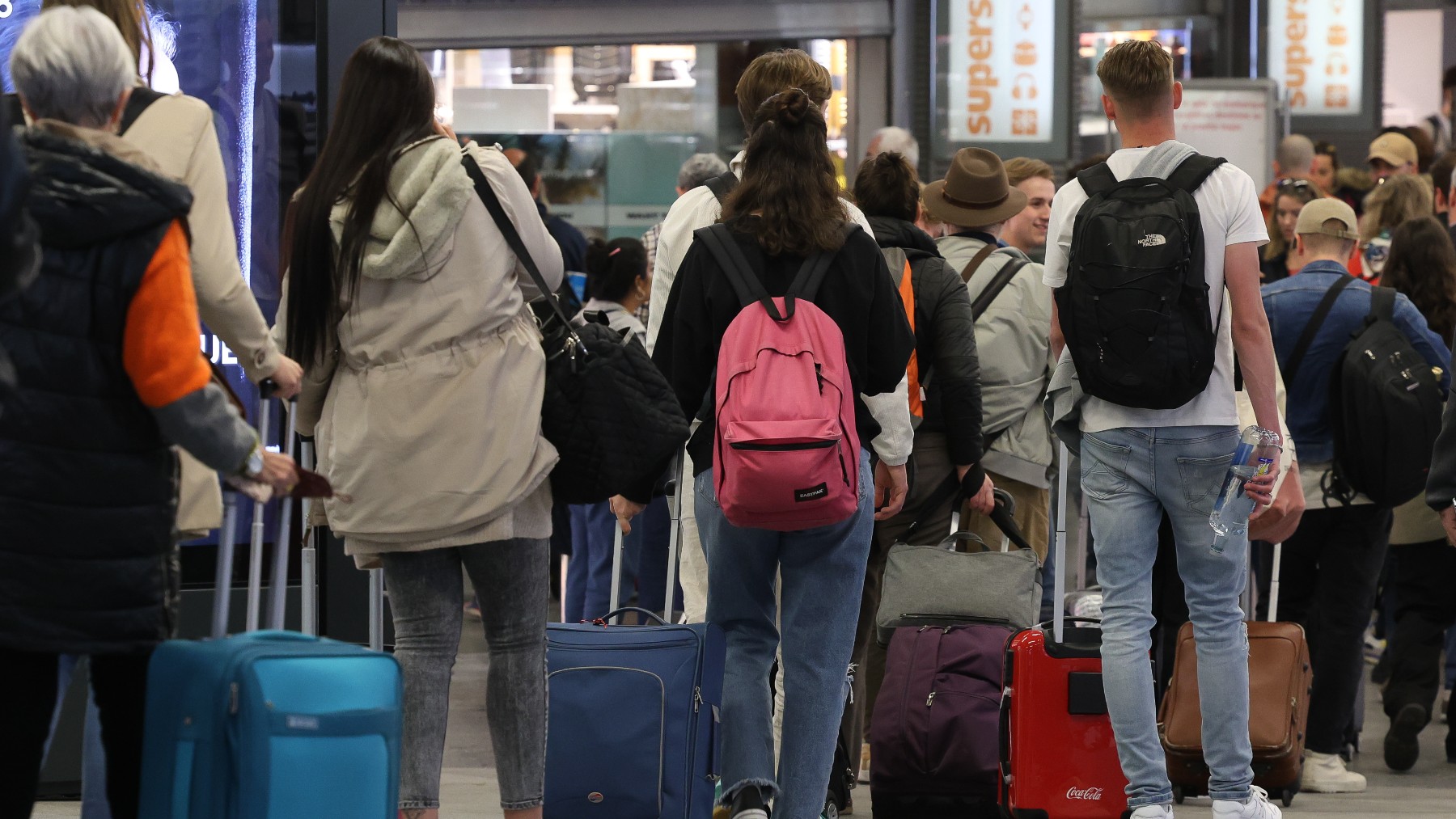 Un grupo de jóvenes esperan en la estación Almudena Grandes-Atocha Cercanías.