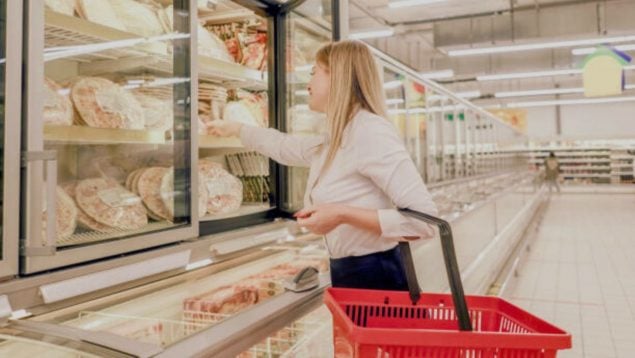 Foto de una mujer que compra pizza en un supermercado