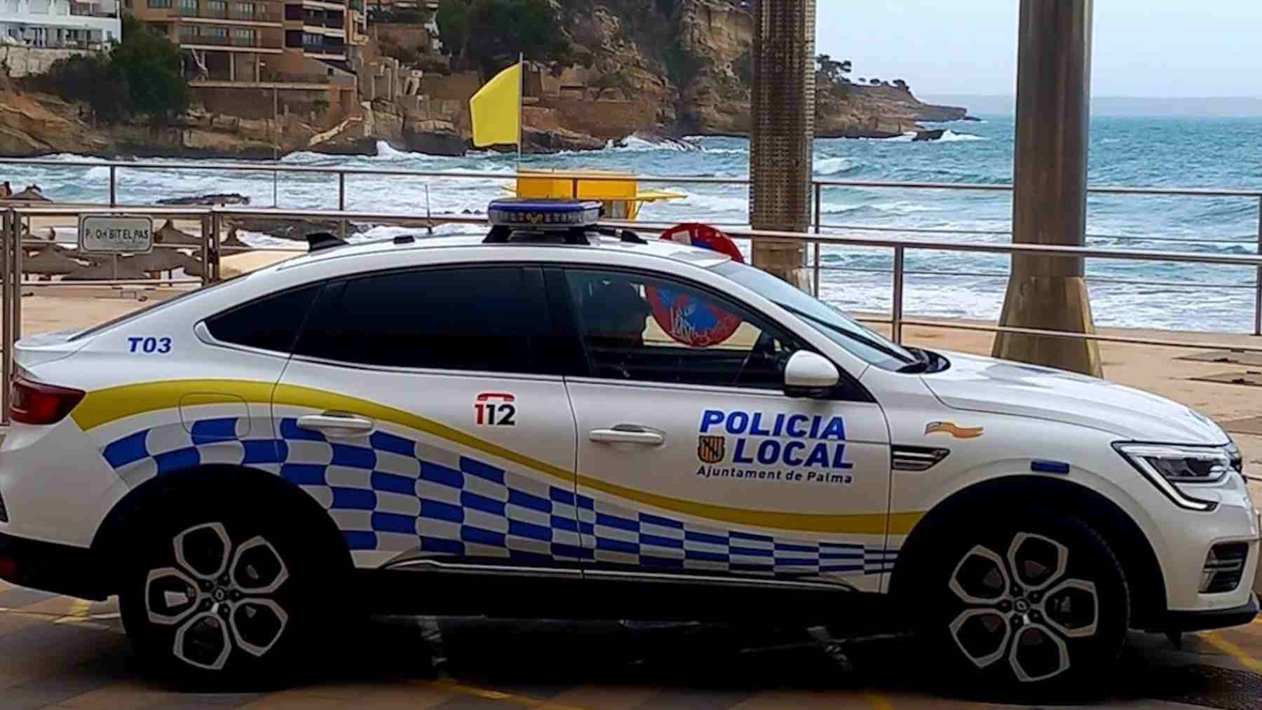 Vehículo de la Policía Local de Palma frente a la costa.