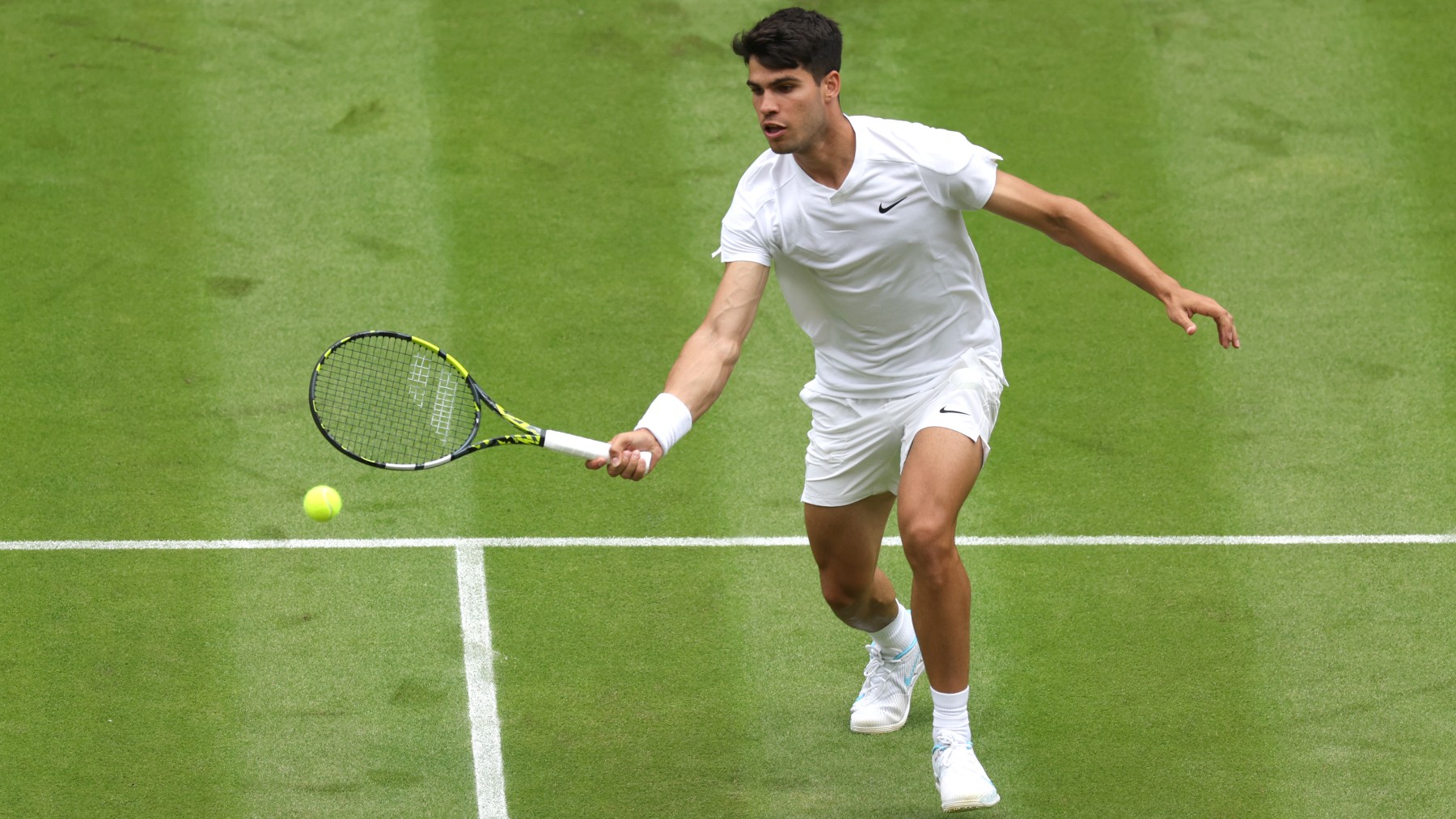 Carlos Alcaraz golpea una volea en un partido de Wimbledon. (Getty)