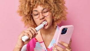 Mujer usando cepillo de dientes eléctricos