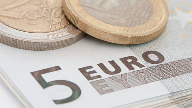 Foto de billete de 5 euros y encima moneda de euro y de dos euros.