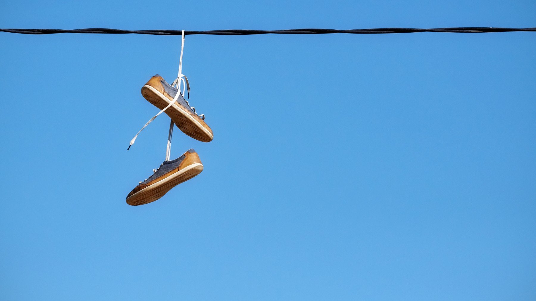 Zapatillas colgadas en cables. (iStock)