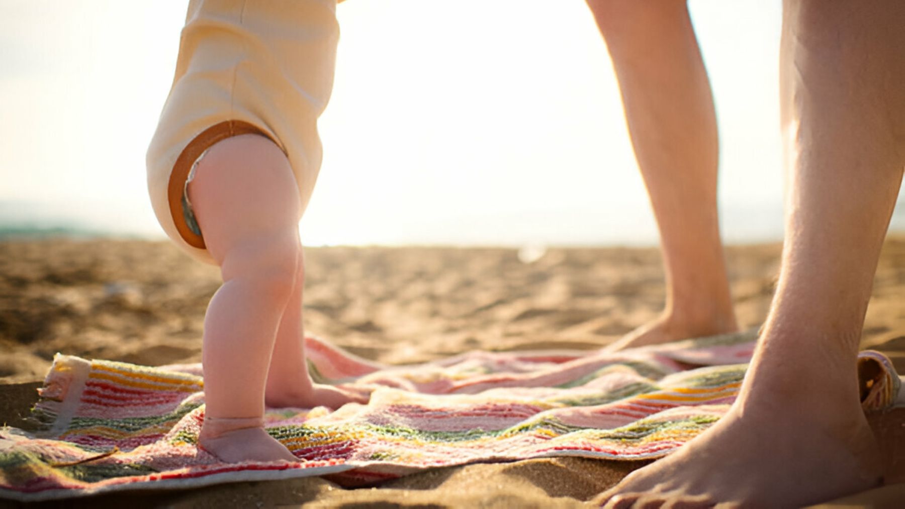 Pies de un bebé sobre una toalla de playa.