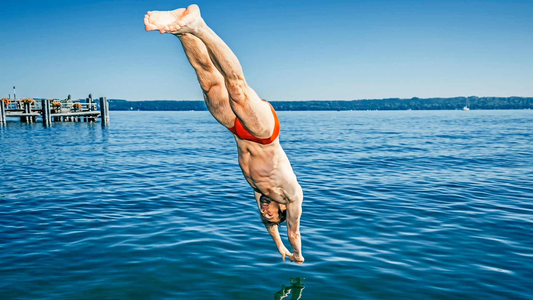 Un hombre se tira de cabeza en el mar.