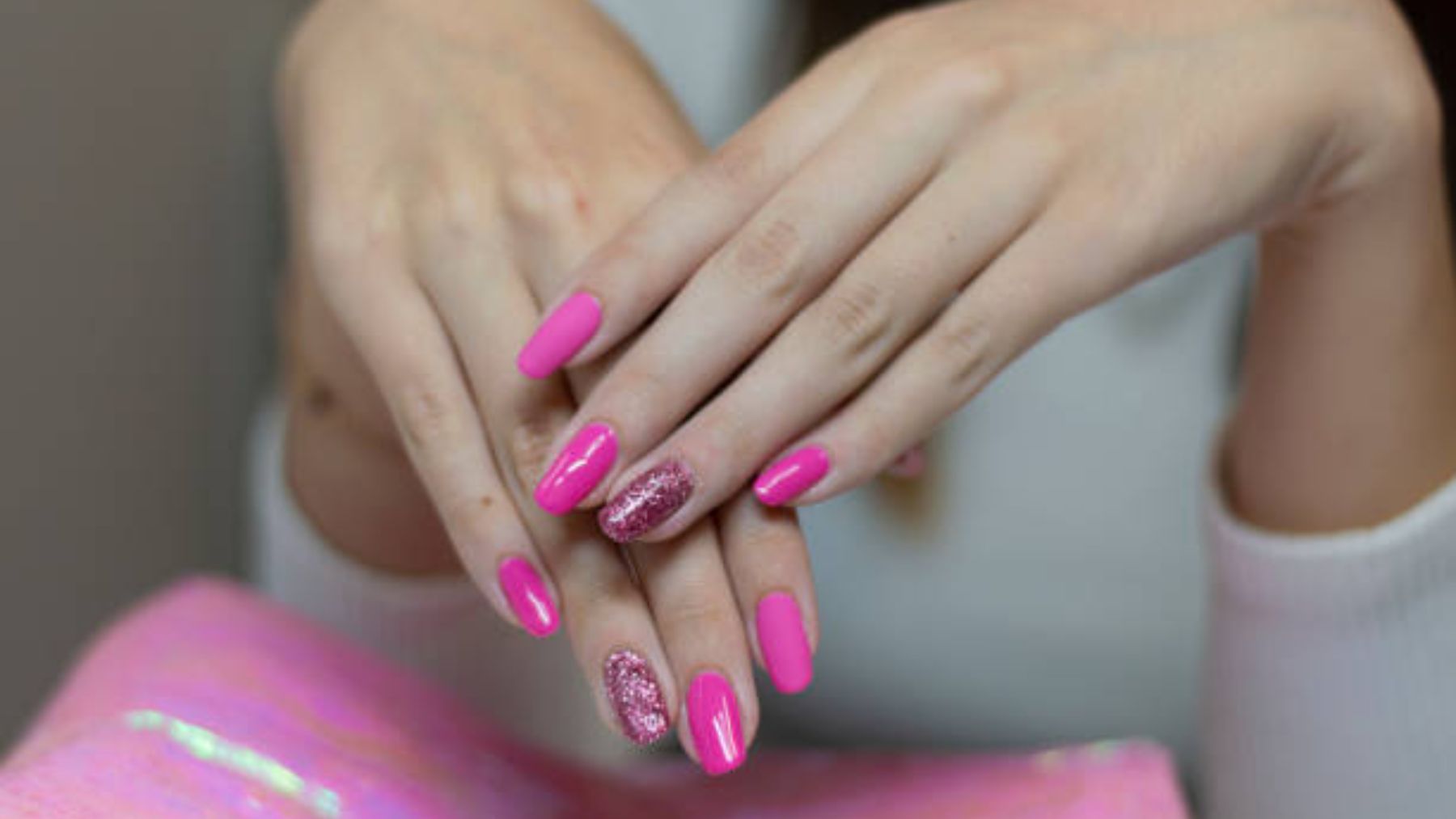 Mujer con una manicura de uñas rosas.