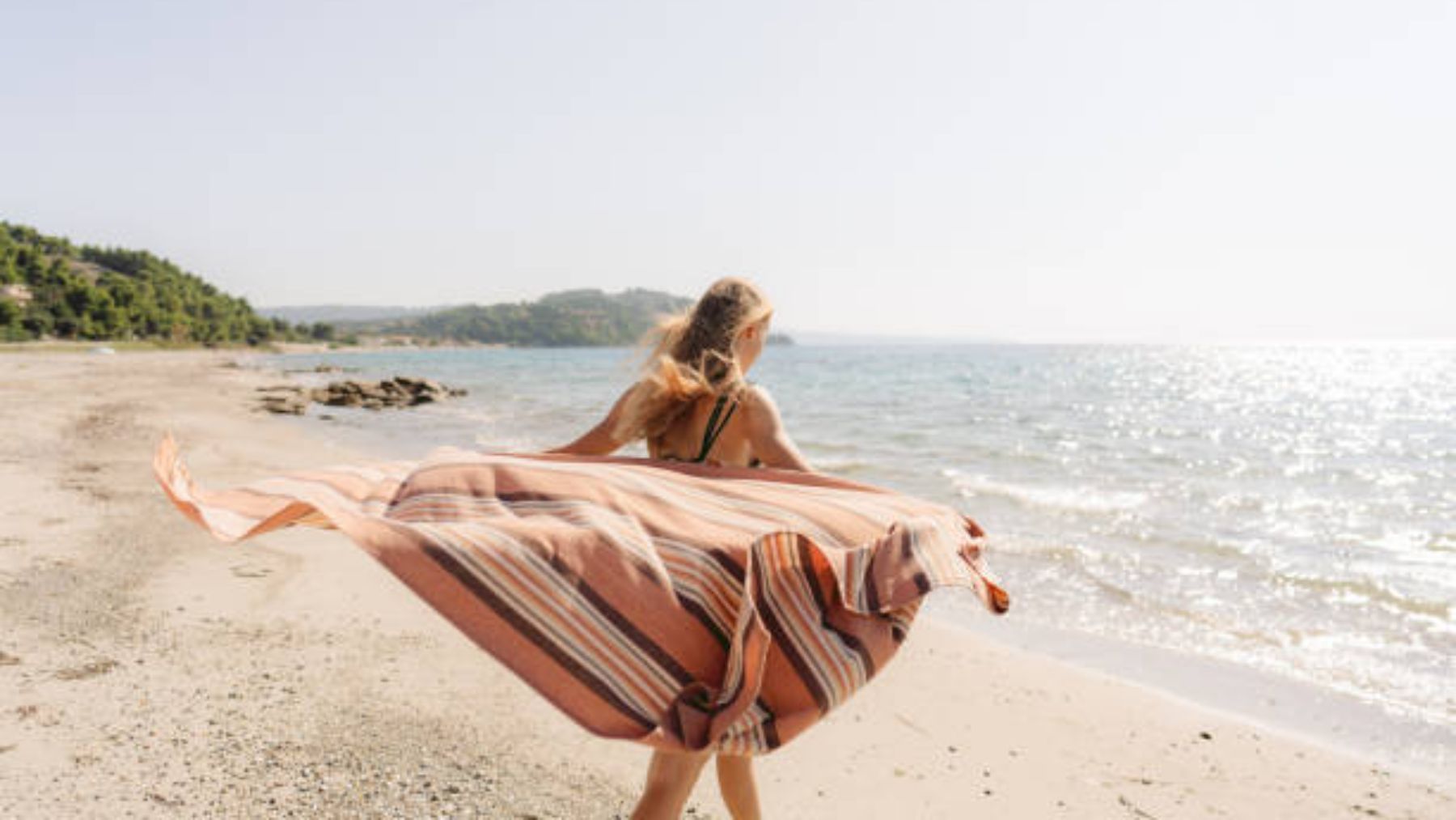 Mujer con toalla en la playa.