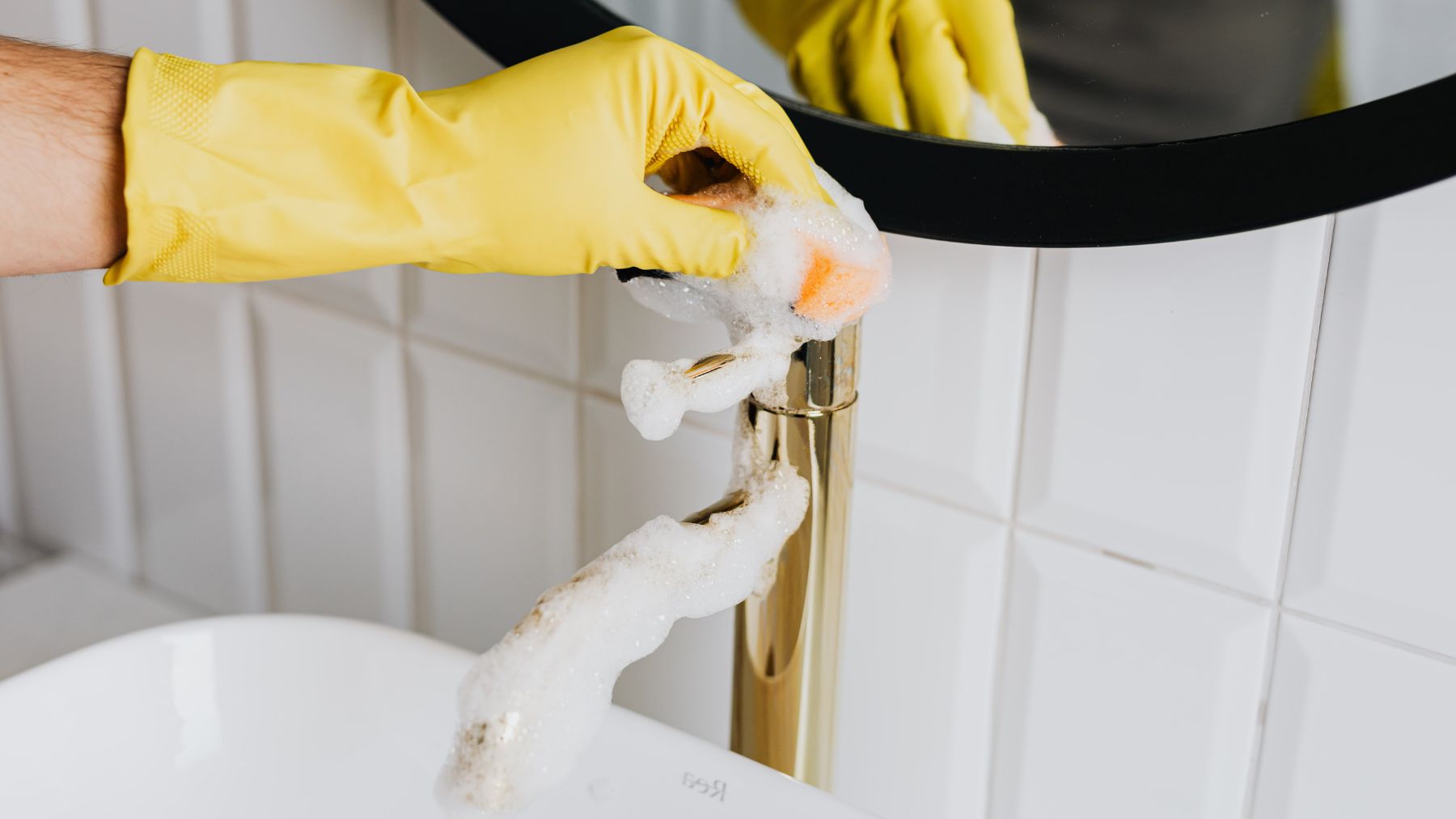 Una persona limpiando el grifo del baño.