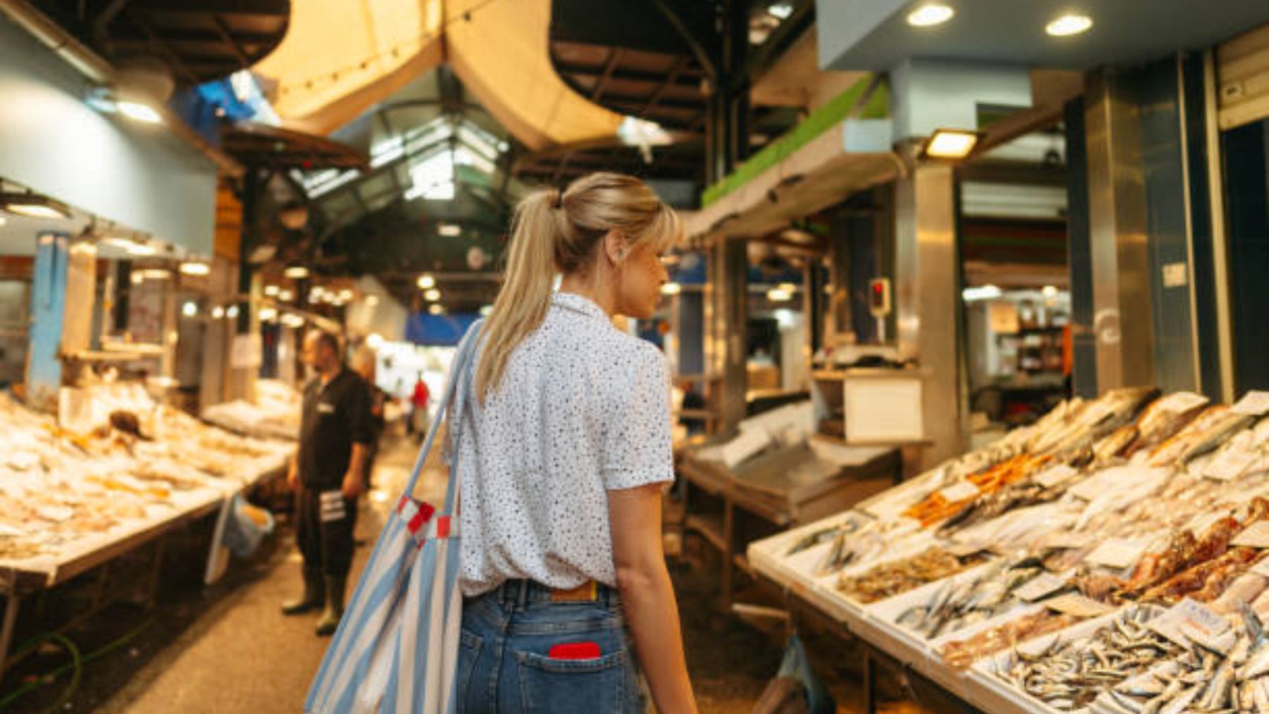 Mujer comprando pescado.