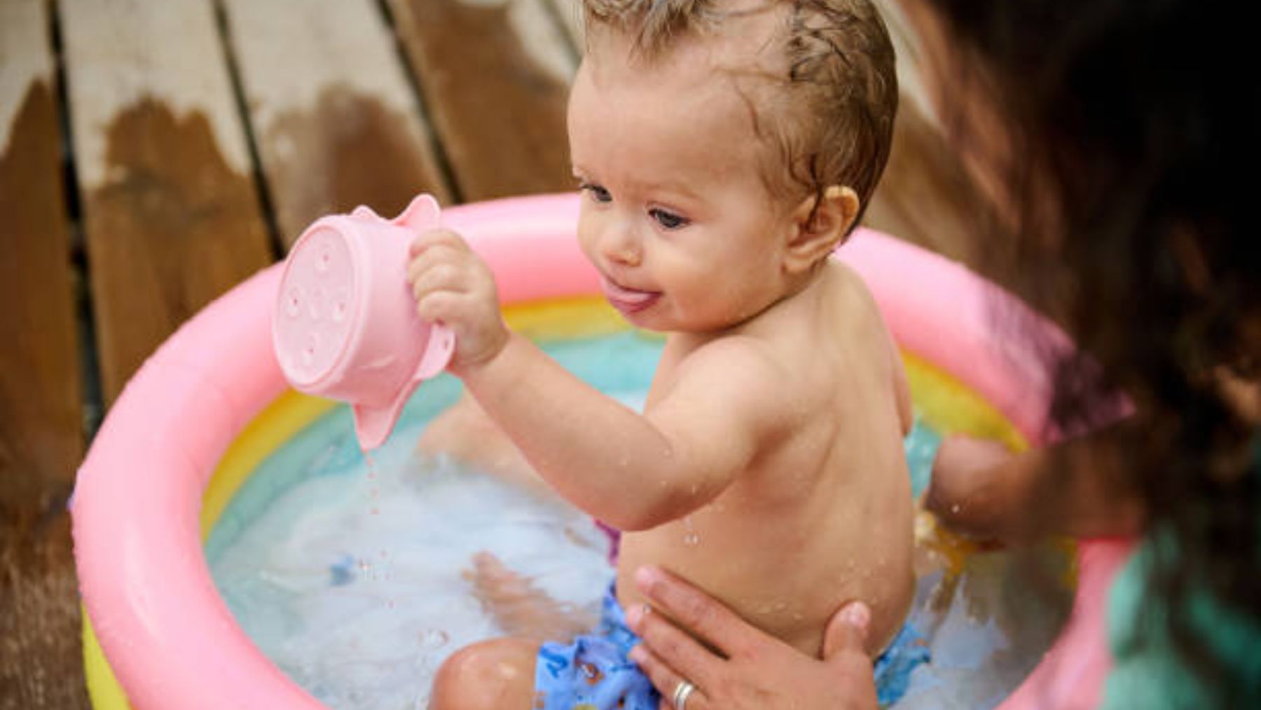 Bebé jugando en una piscina hinchable.