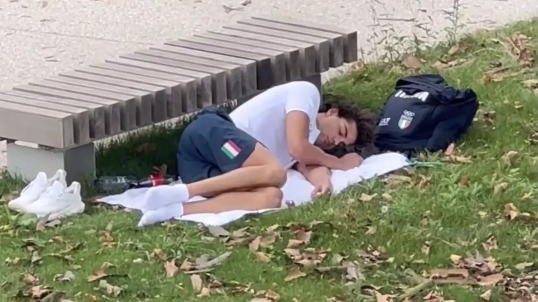 El medallista Thomas Ceccon durmiendo en un parque.