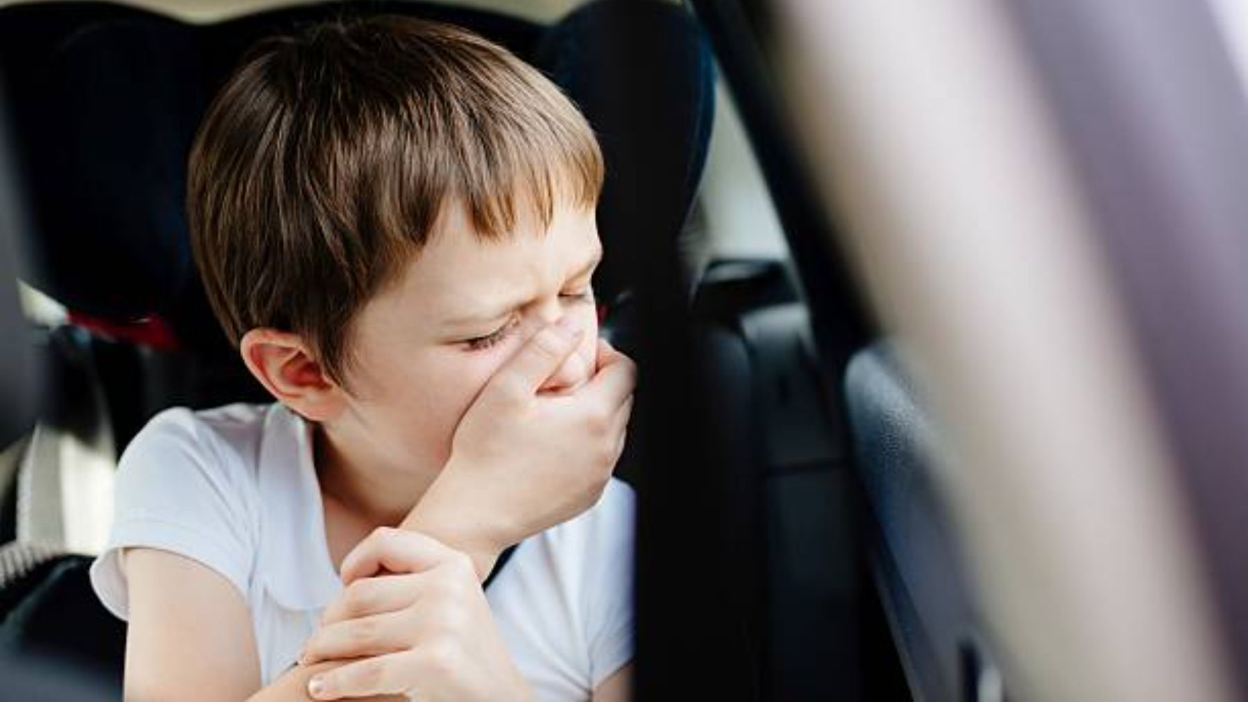 Niño mareado en el coche.