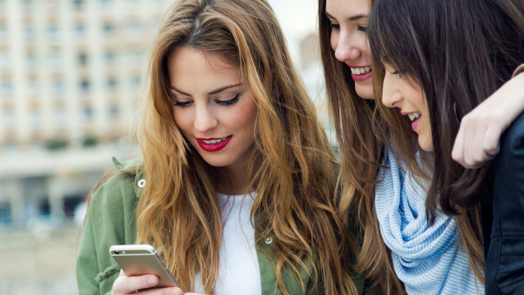 Varias amigas envían mensajes de WhatsApp en un iPhone.Foto: Freepik