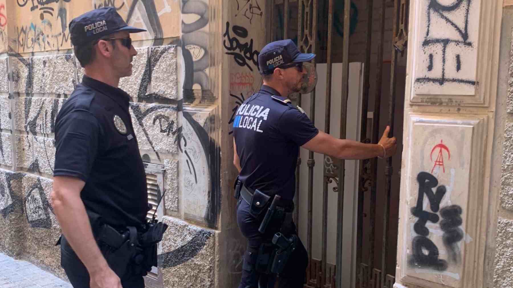 Agentes de la Policía Local de Palma en la puerta de la casa okupa.