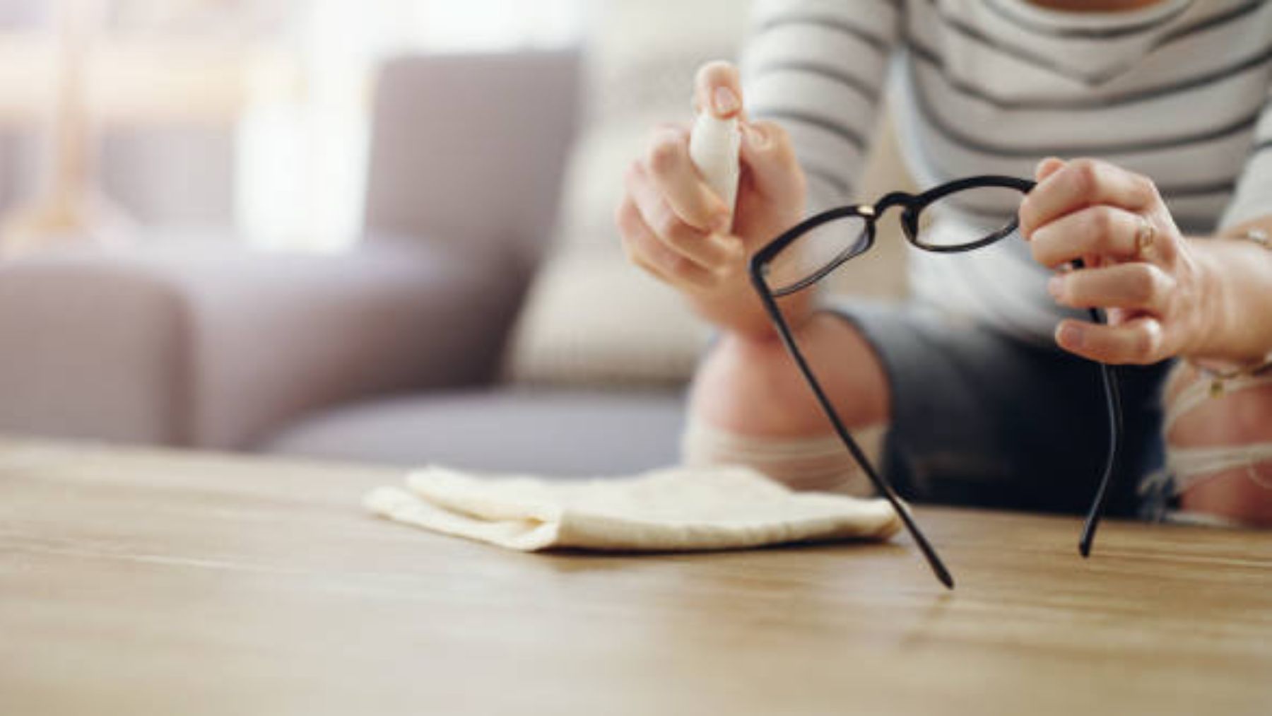 Mujer limpiando sus gafas.