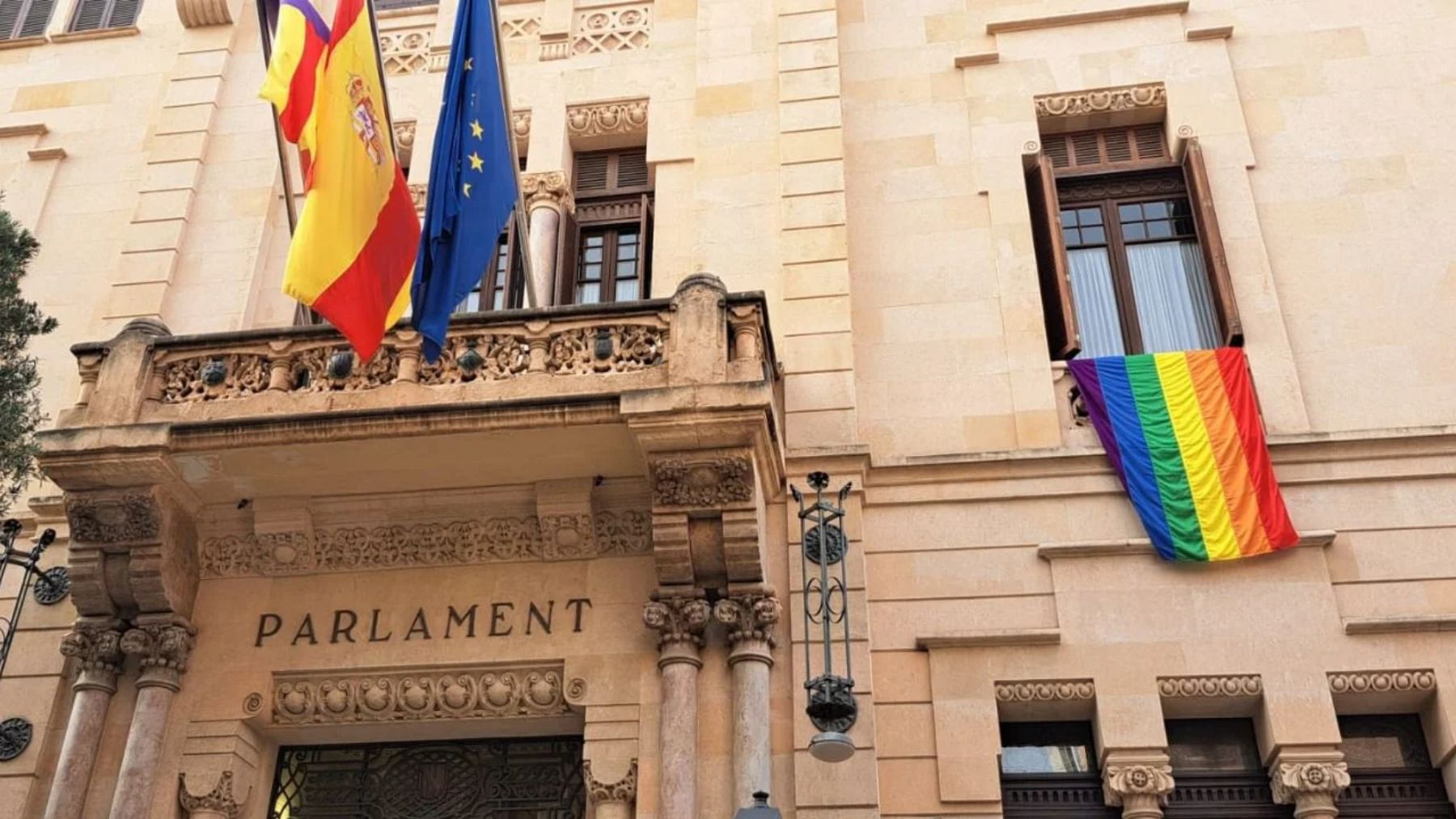 La bandera LGTBI en la fachada del Parlament balear.