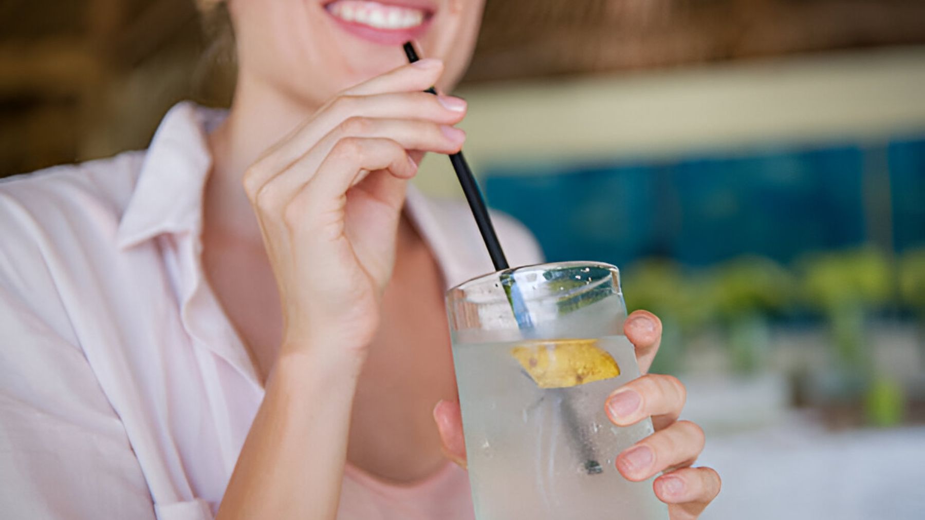 Mujer bebiendo agua de coco.